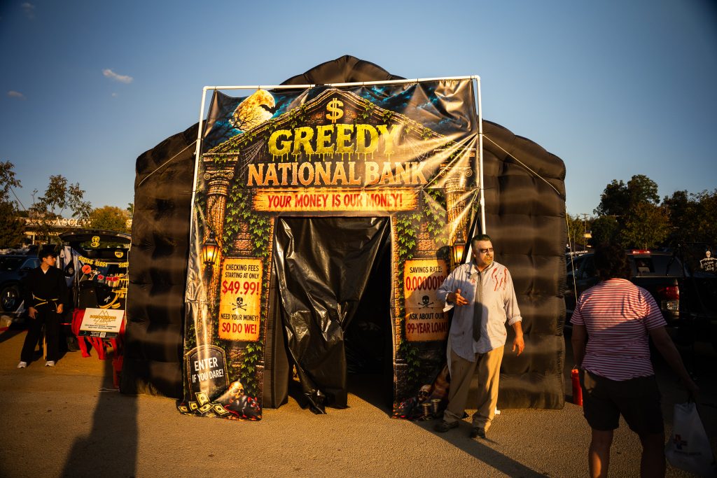 Greedy National Bank-themed haunted tent with costumed hosts at Trunk or Treat, Lake Ridge Village in Dallas