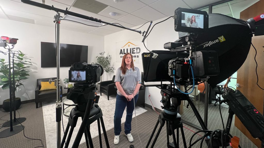 Woman being filmed by two cinema cameras on a bright interview set